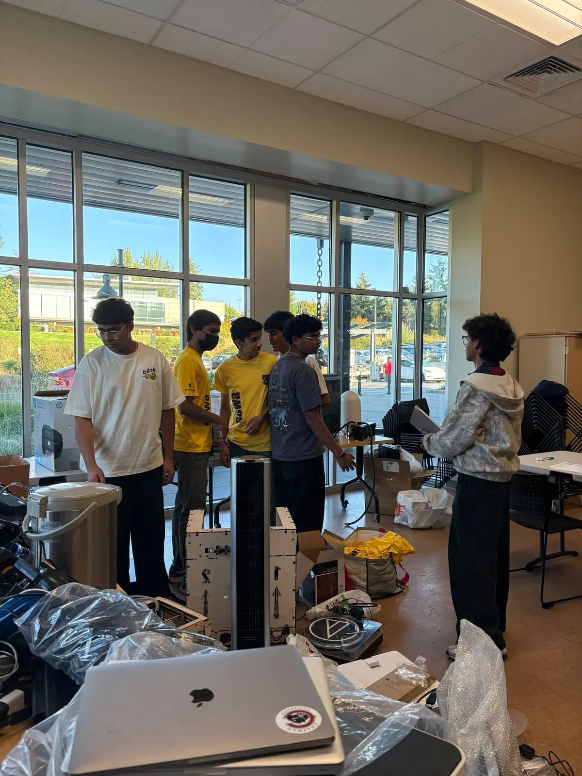 Volunteers gathered around tables holding donated laptops and cables